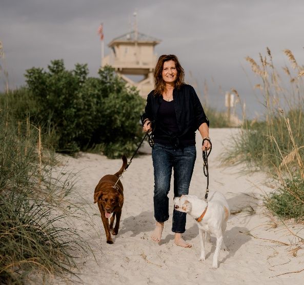 Kimberly walking her two rescued dogs on a beach path