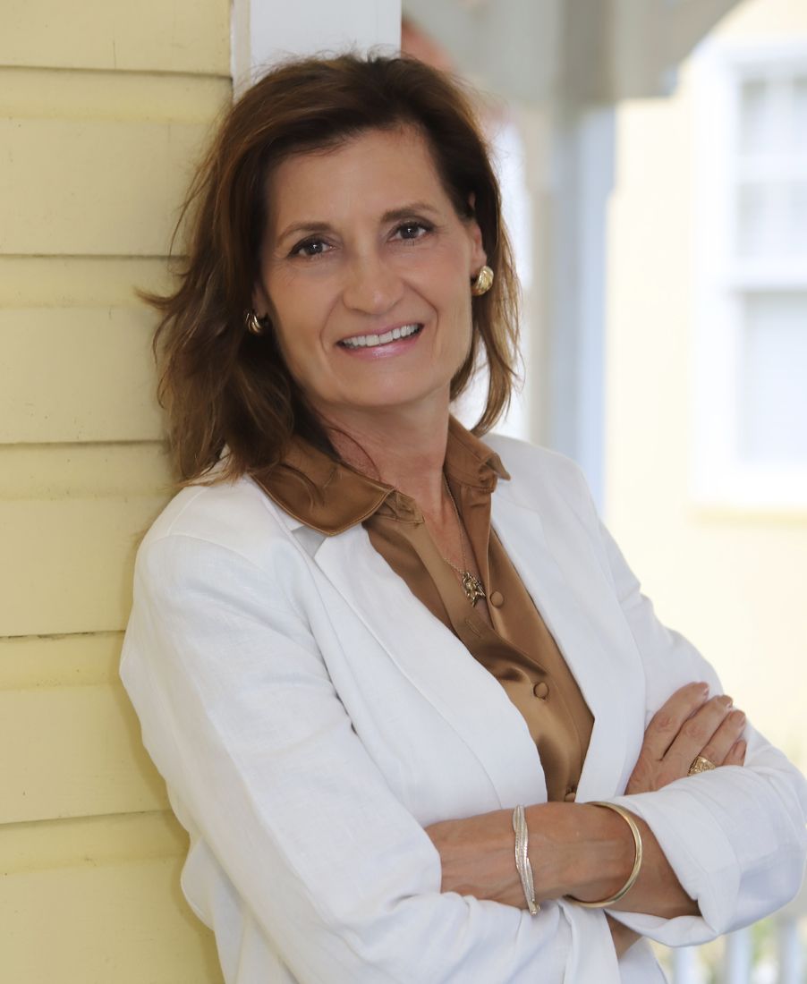 Kimberly J. Rimmer, attorney, in a white blazer against a yellow wall